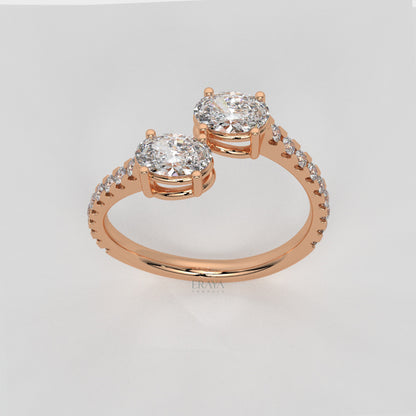 Rose gold ring with two round diamonds on a light gray background