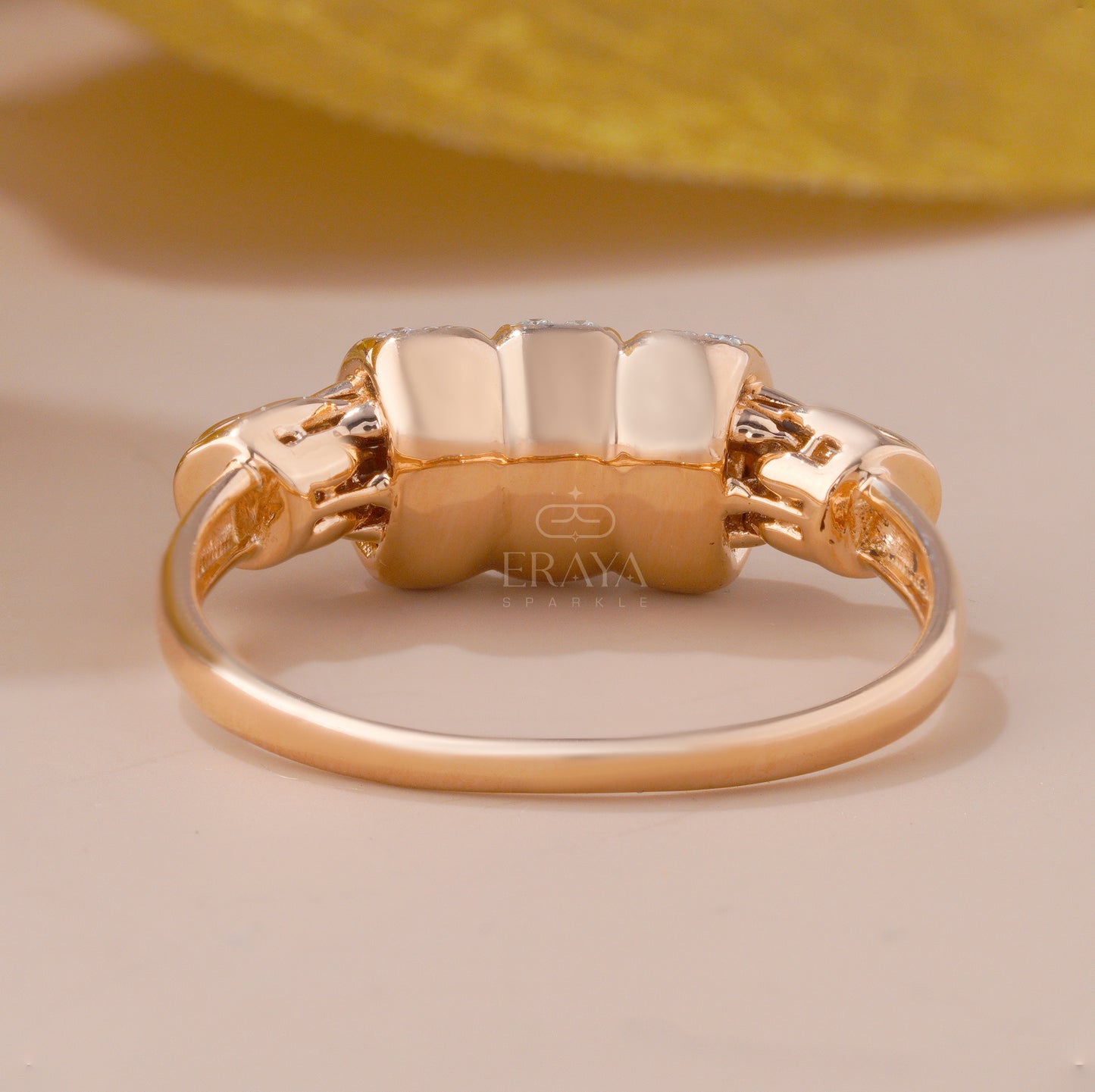 Gold ring with a textured band on a beige background