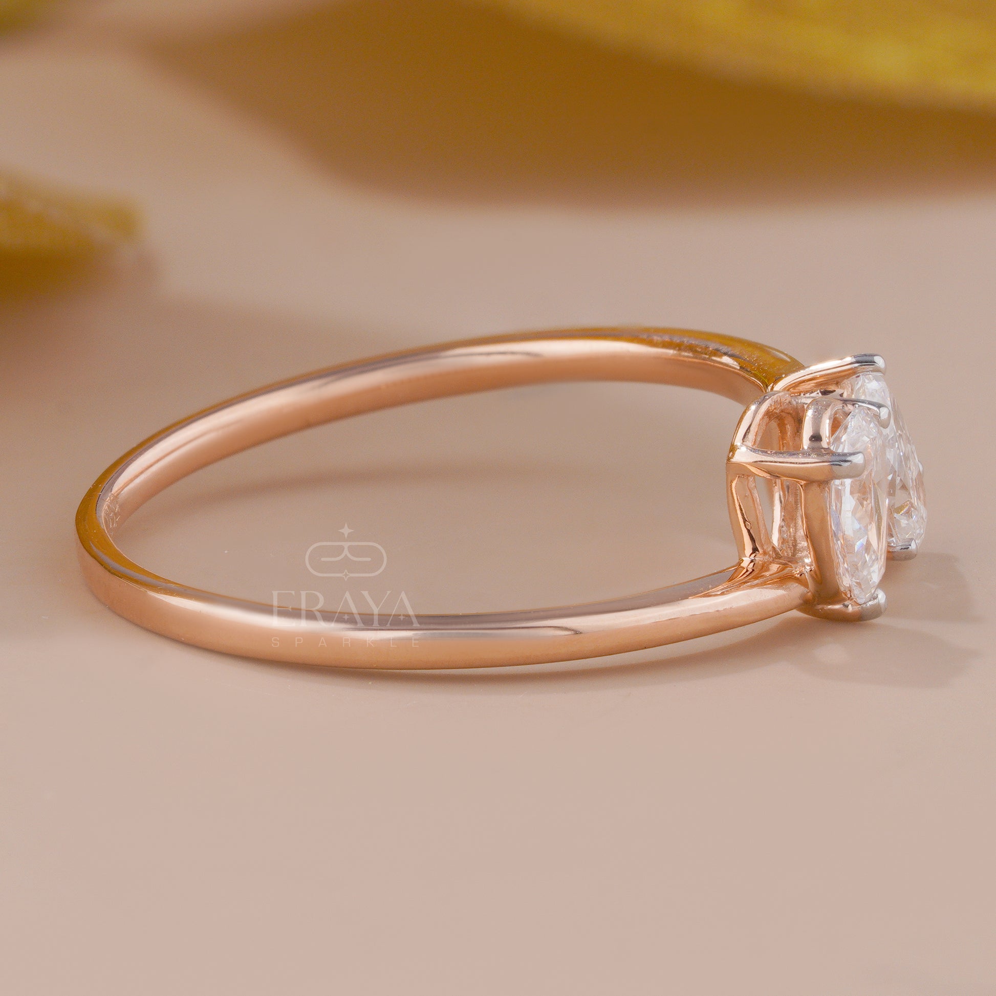 Rose gold ring with a diamond on a beige background