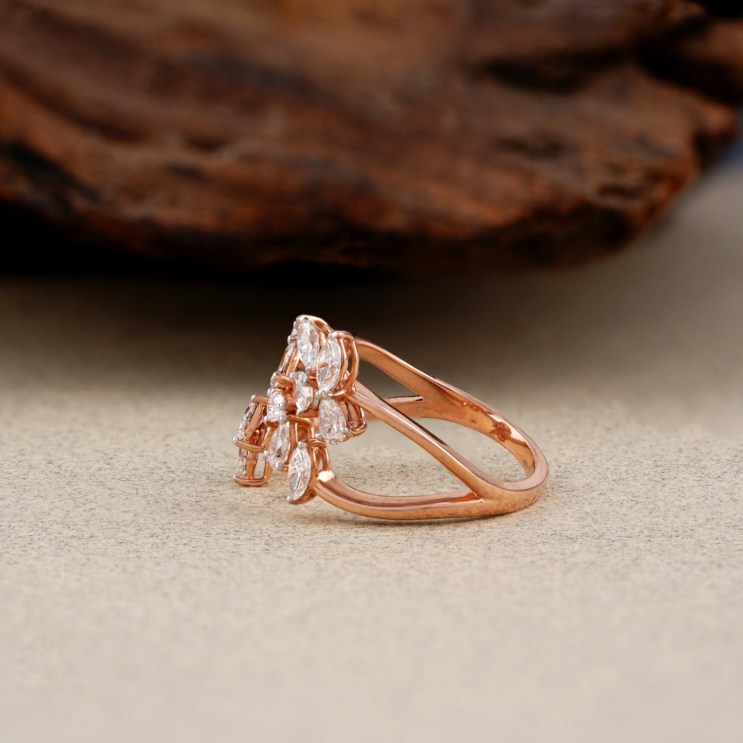 Rose gold ring with diamonds on a textured surface