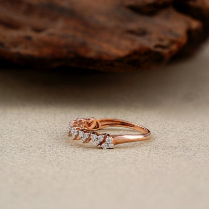 Rose gold ring with diamonds on a textured surface