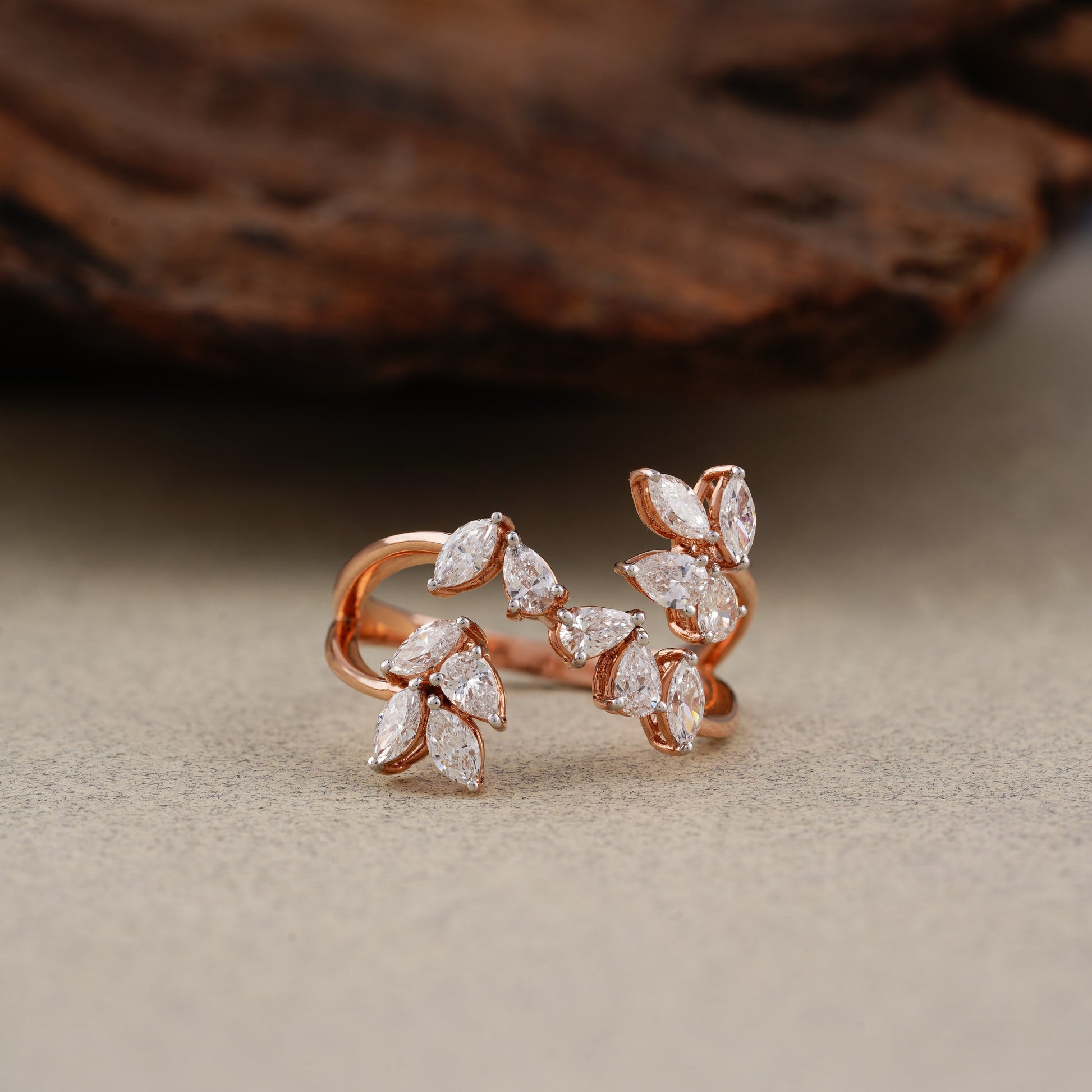 Rose gold earrings with diamond-like stones on a neutral background