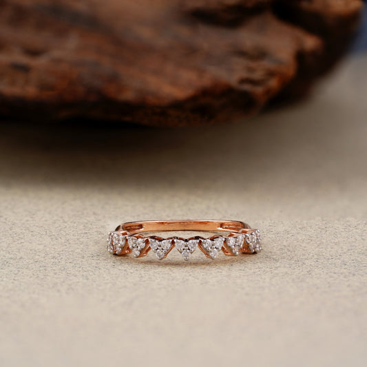 Rose gold ring with diamonds on a textured surface