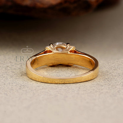 Gold ring with a diamond on a textured surface, featuring the brand 'Eraya'.