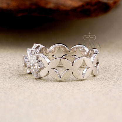 Silver ring with intricate design on a beige surface, branded 'Eraya Sparkle'.