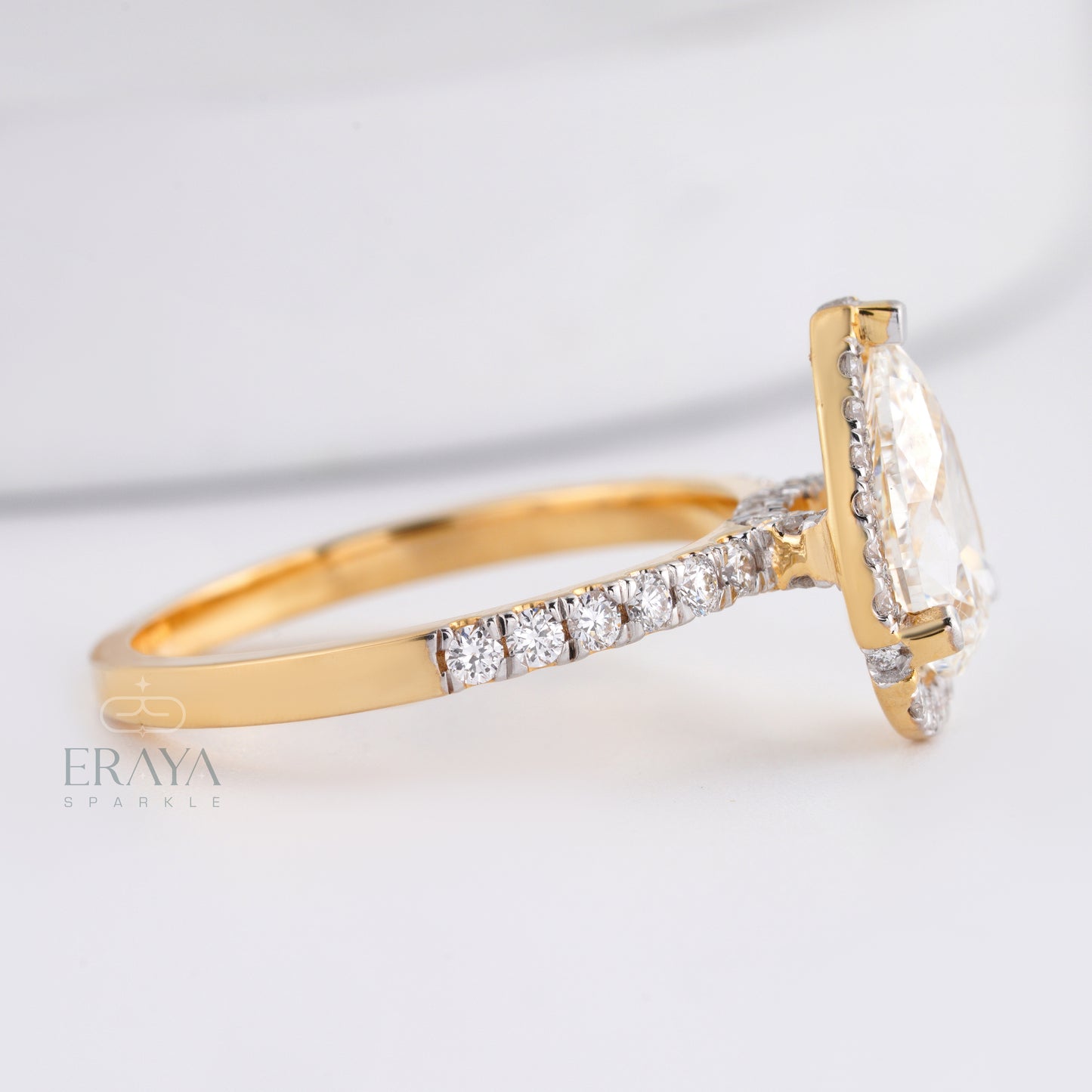 Gold ring with a large diamond and smaller diamonds on a light background, featuring the brand 'Eraya'.