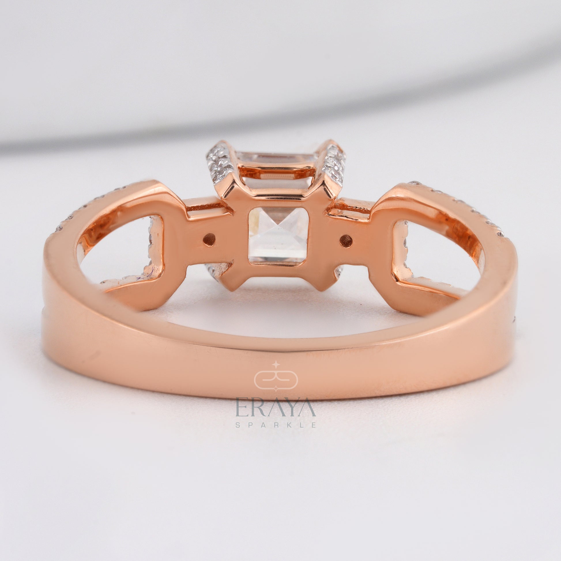 Rose gold ring with diamond accents on a light gray background