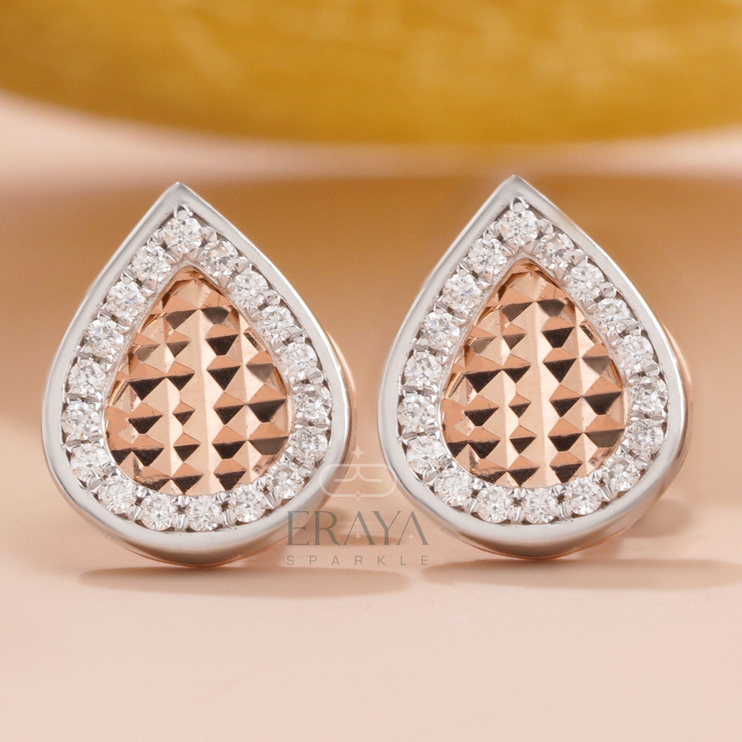 Front view of teardrop diamond stud earrings with halo design