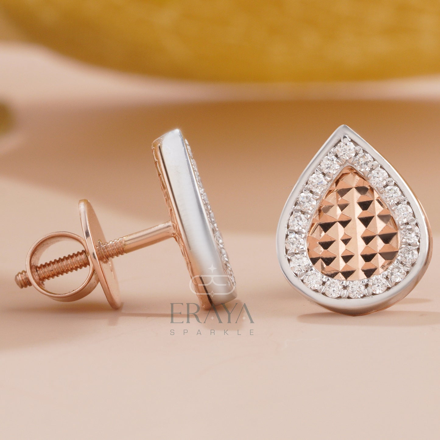 Side and front angle of teardrop diamond stud earrings showing halo and depth