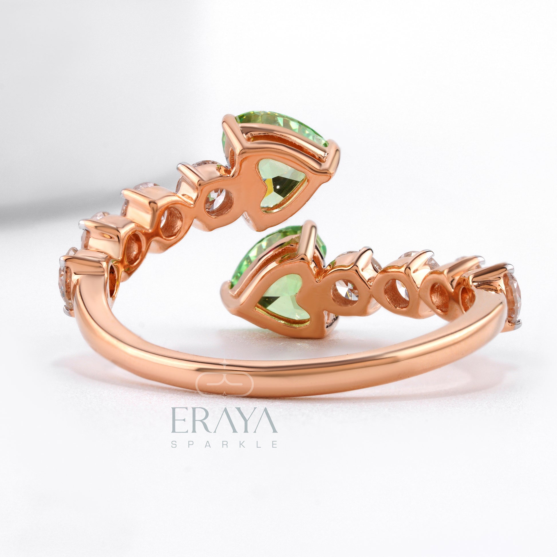 Rose gold ring with green gemstones on a white background, featuring the brand 'Eraya'.