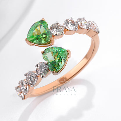 Rose gold open ring with heart-shaped green stones and diamond accents