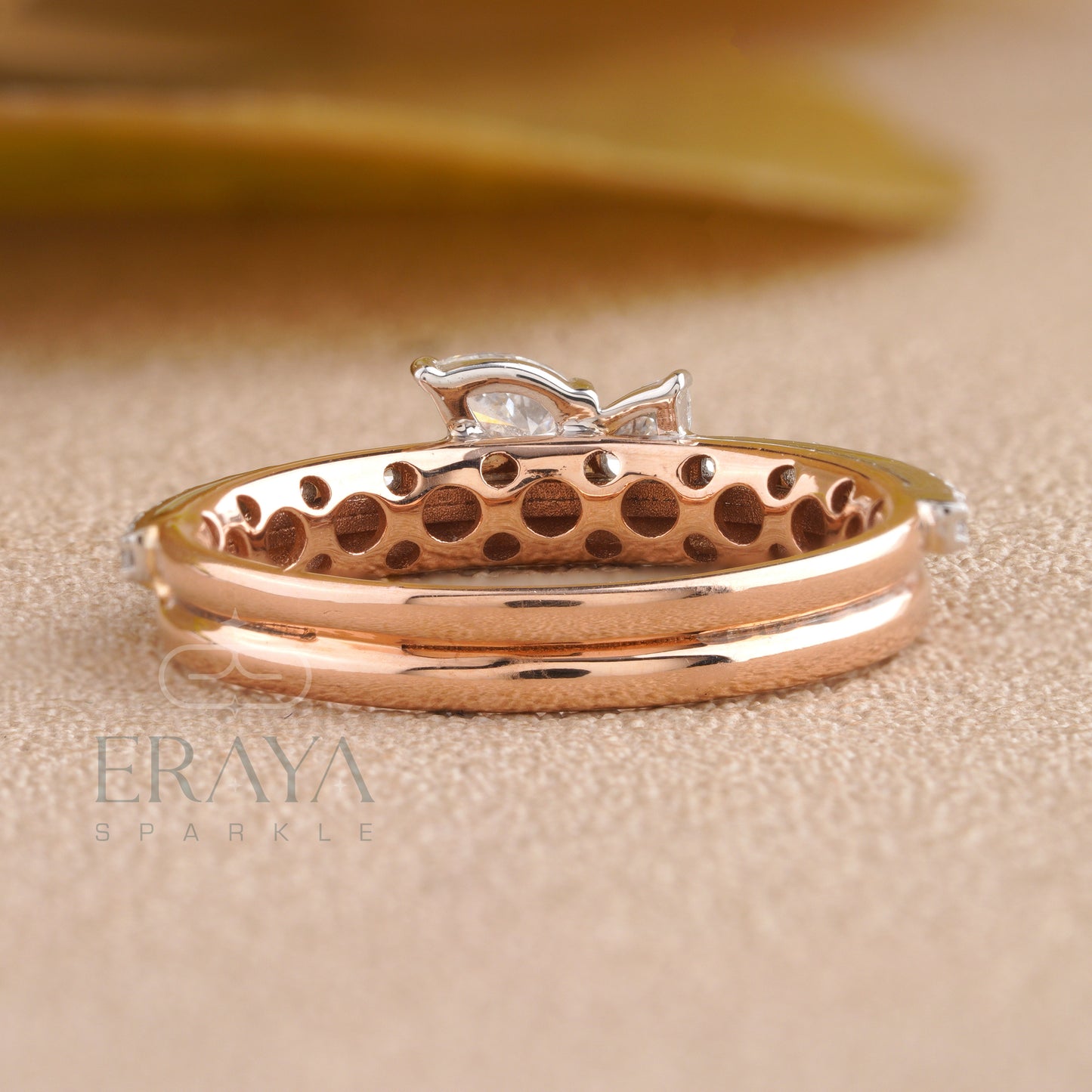 Rose gold ring with a dolphin design on a beige background, featuring the brand 'ERAYA SPARKLE'.