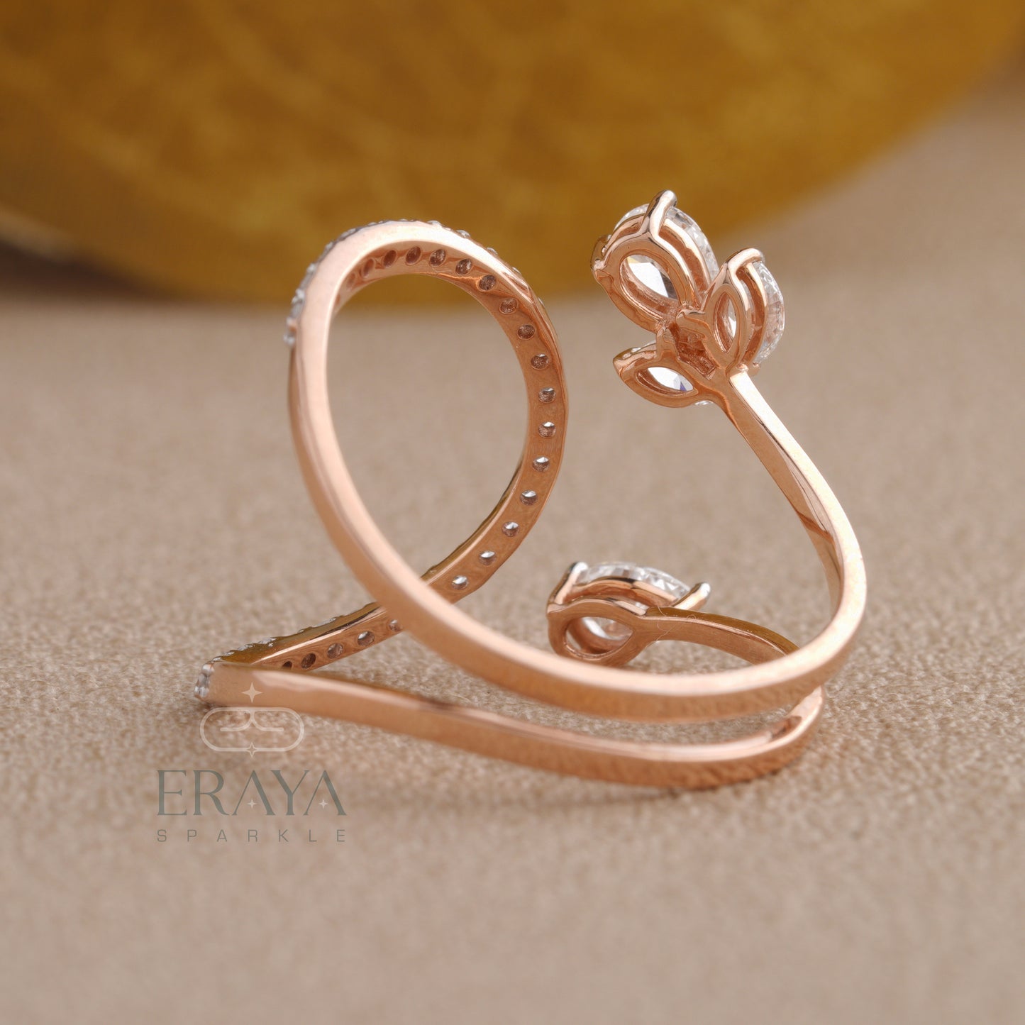 Rose gold ring with floral design on a beige background, featuring the brand 'ERAYA'.