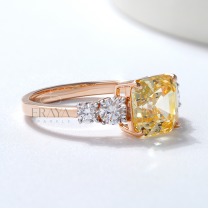 Rose gold ring with a yellow diamond and smaller diamonds on a white background