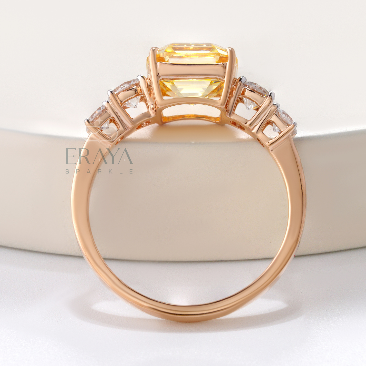 Rose gold ring with a large central gemstone and smaller stones on a light background
