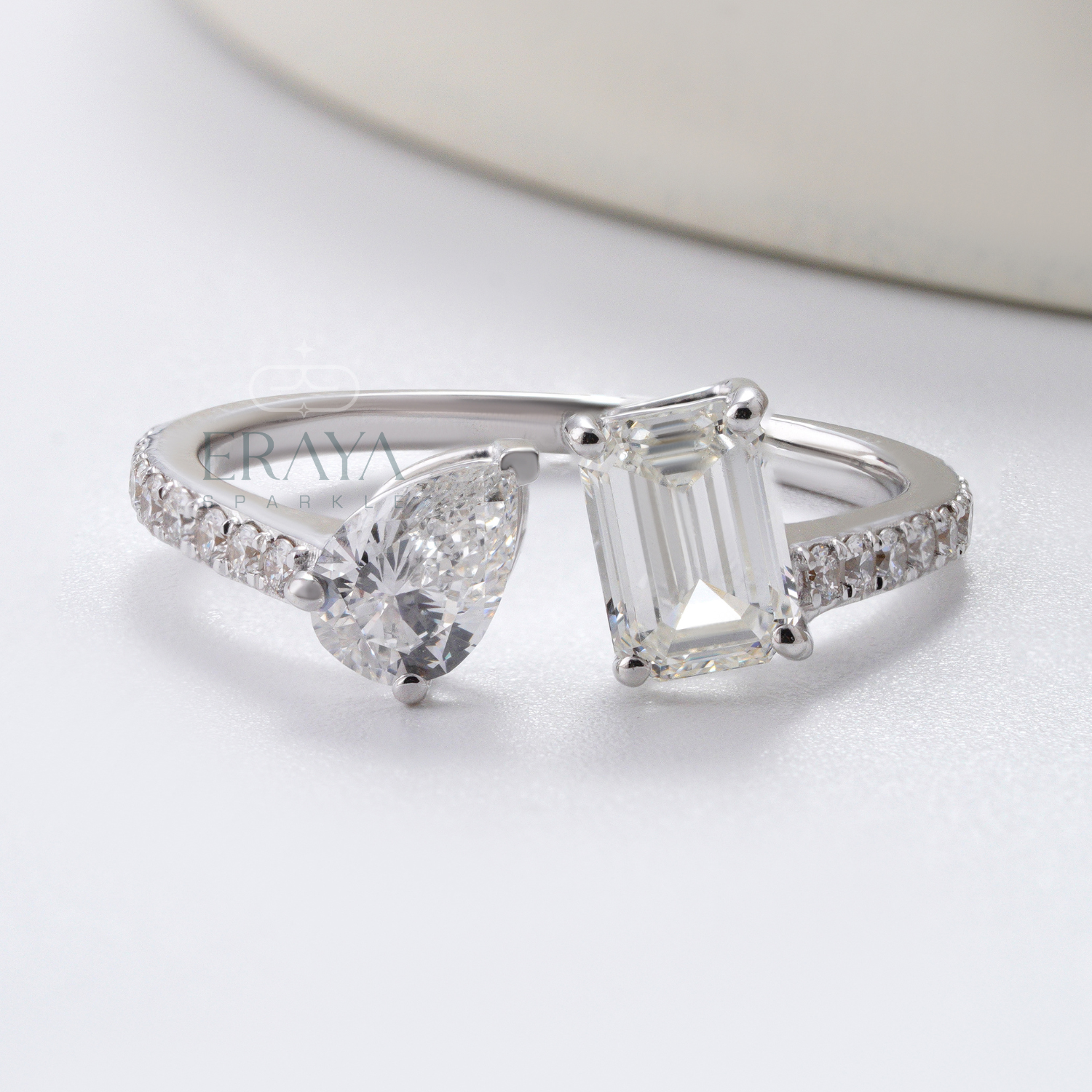 Diamond ring with heart and emerald cut stones on a white background