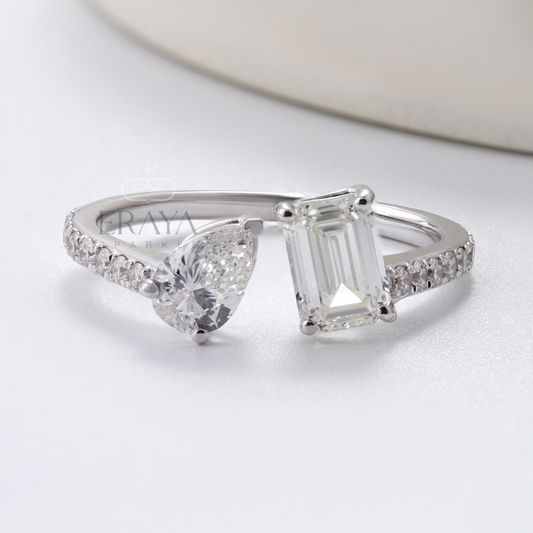 Diamond ring with heart and emerald cut stones on a white background