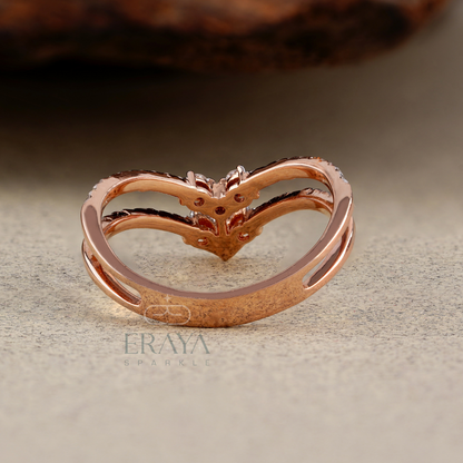 Rose gold heart-shaped ring on a textured surface with 'Eraya' branding.
