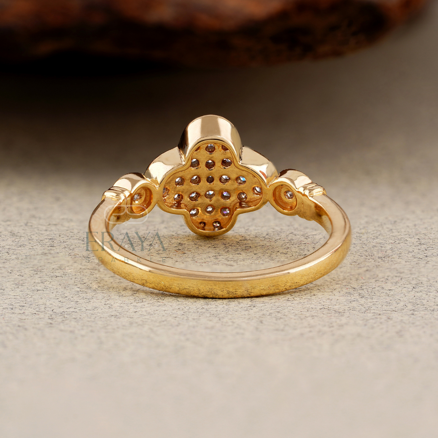 Gold ring with intricate design on a textured surface