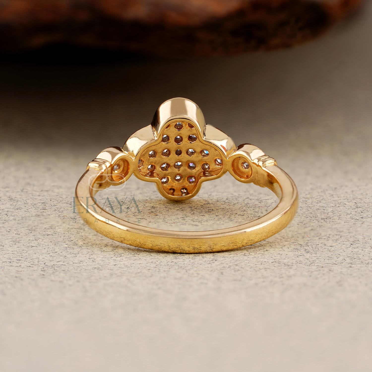 Gold ring with intricate design on a textured surface