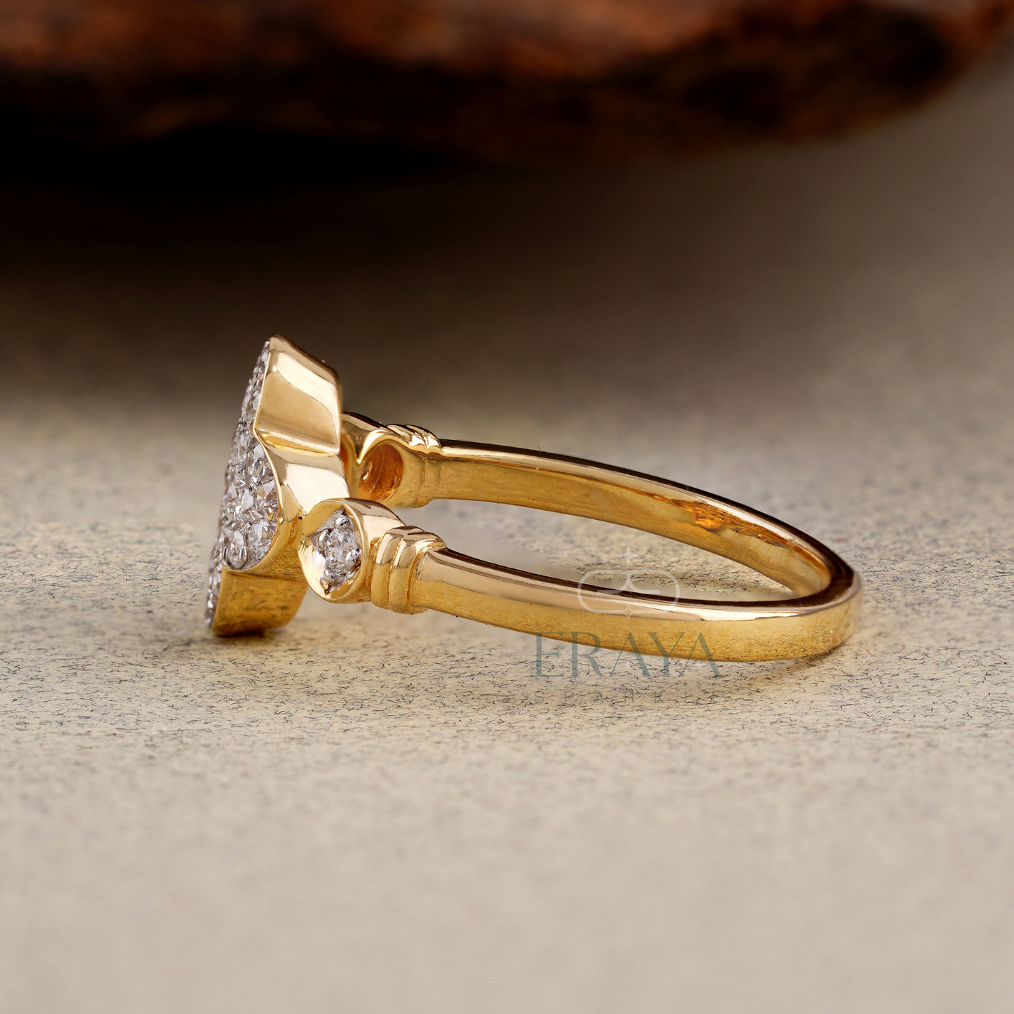 Gold ring with a pear-shaped diamond on a textured surface