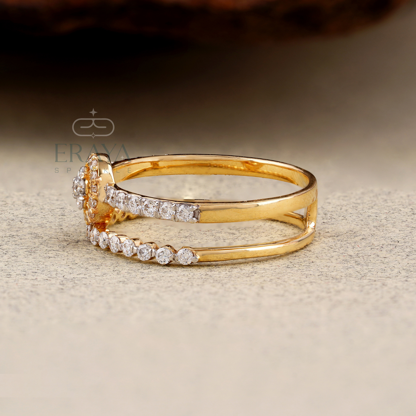 Gold ring with diamonds on a textured surface, featuring the brand 'ERAYA'.