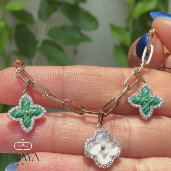 360° hands-on view of floral charm paperclip bracelet showing clover charms, diamonds, and clasp
